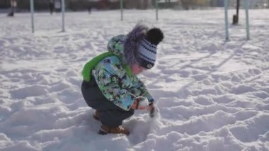 Kar kış Park ile oynayan küçük bir çocuk. Güneşli kış günü. Eğlence ve oyun temiz havada.