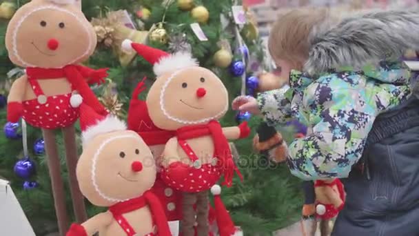 Apa és fia válasszon egy karácsonyfa a boltban. Karácsonyi eladó a játékok és a karácsonyfák, amíg karácsony. Karácsonyi ajándékot szeretteinek — Stock videók