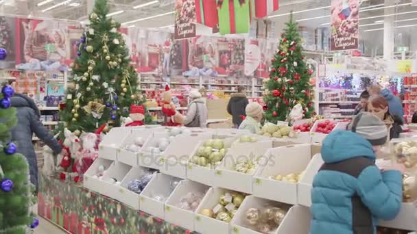 Πρώιμη Γιορτινή Πώληση παιχνιδιών και χριστουγεννιάτικα δέντρα μέχρι τα Χριστούγεννα. Άνθρωποι στο σούπερ μάρκετ είναι ψώνια πριν το νέο έτος. Χριστουγεννιάτικα δώρα για τους αγαπημένους αυτούς — Αρχείο Βίντεο
