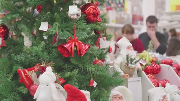 Νοβοσιμπίρσκ, Ρωσική Ομοσπονδία - Νοέμβριος 25,2017: πώληση παιχνιδιών και χριστουγεννιάτικα δέντρα μέχρι τα Χριστούγεννα. Άνθρωποι στο σούπερ μάρκετ είναι ψώνια πριν το νέο έτος. Χριστουγεννιάτικα δώρα για τους αγαπημένους αυτούς. — Αρχείο Βίντεο