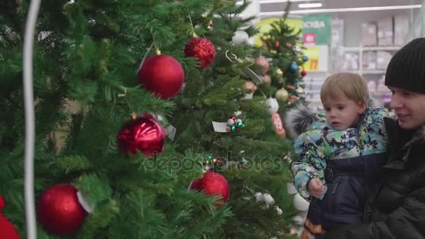 Verkoop van speelgoed en kerstbomen tot xmas. Mensen in de supermarkt winkelen voor het nieuwe jaar. De giften van Kerstmis voor dierbaren. — Stockvideo