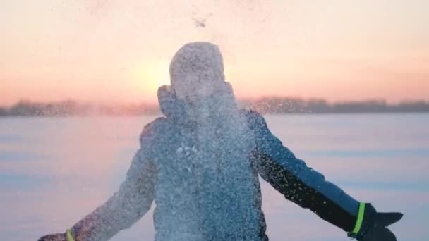 Een kind speelt in de winter buiten loopt, sneeuw gooit naar de top. Prachtige zonsondergang. Actieve outdoor sporten — Stockvideo