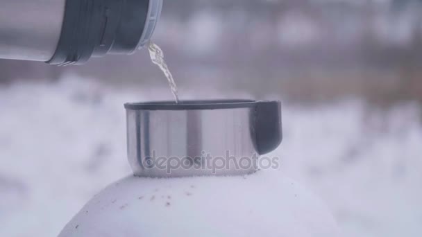 Pour the hot tea into the Cup in the winter in the open air — Stock Video