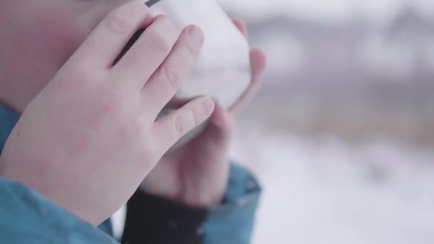 Dítě pije čaj v zimě venku v parku — Stock video