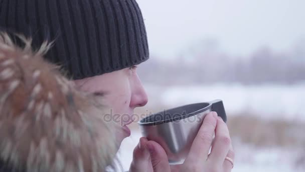 冬の公園で屋外で熱いお茶を飲む男。健康的なライフ スタイル、野外を歩いています。 — ストック動画