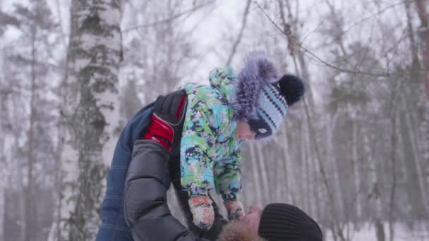 Jonge vader spelen in het Park met zijn jonge zoon. Gooit de baby hoog boven zijn hoofd. Actieve spelletjes in de frisse lucht — Stockvideo