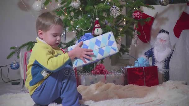 Kerst cadeau verrassing. Een kind wordt geopend aanwezig. Nieuwjaar en Kerstmis — Stockvideo