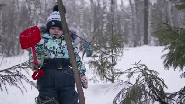 Un petit enfant jouant avec la neige dans le parc d'hiver. Hivers ensoleillés. Fun et jeux dans l'air frais . — Video