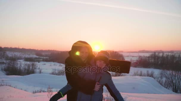 Una giovane ragazza con un bambino che gioca nel parco invernale. Passeggiate all'aria aperta. Tramonto — Video Stock