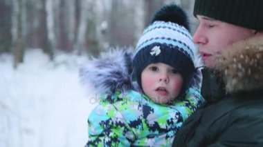 Genç bir baba çocuğunu onun kollarında tutar. Hassasiyet ve sevgili babam kucaklama.