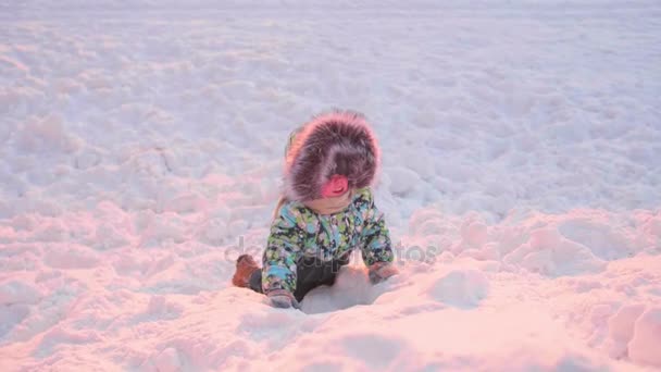 Małe dziecko bawi się w winter Park. Słoneczny zimowy dzień. Gry i zabawy na świeżym powietrzu. — Wideo stockowe