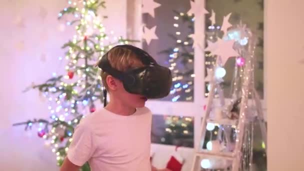 Virtual reality glasses. A teenager playing a computer game with a helmet — Stock Video