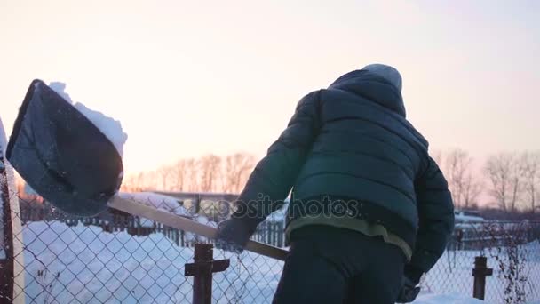 El ile bir kürek ile kadın kar sokaktan, bölge temizlenirken. Kış iş ve derin kar temizleme — Stok video