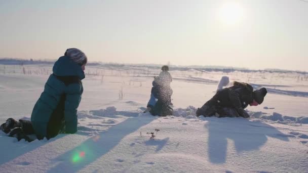 Los niños que juegan en invierno al aire libre, lanzan bolas de nieve. Deportes activos al aire libre — Vídeos de Stock