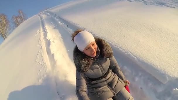 Chica feliz montando en una colina nevada. En cámara lenta. Paisaje invernal nevado. Deportes al aire libre — Vídeos de Stock