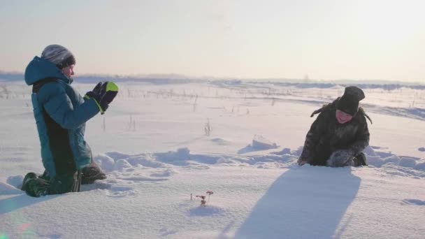 Los niños que juegan en invierno al aire libre, lanzan bolas de nieve. Deportes activos al aire libre — Vídeo de stock