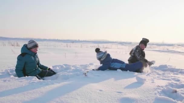 Los niños que juegan en invierno al aire libre, lanzan bolas de nieve. Deportes activos al aire libre — Vídeo de stock