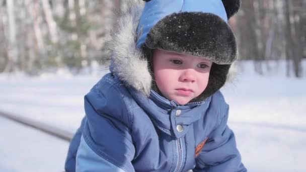 Un niño pequeño camina en el parque de invierno. Un día soleado y helado. Diversión y juegos al aire libre . — Vídeos de Stock