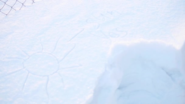 Підліток у зимовому парку малює бурульйон на снігу. Сніжний морозний сонячний день. Веселощі та ігри на свіжому повітрі . — стокове відео