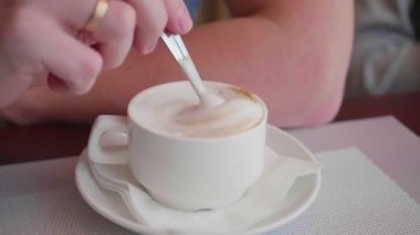 bir adam bir kafede oturuyor ve kahve içiyor. kahve fincanı yakın çekim