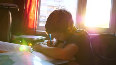 Oturan çocuk okul Danışma ve iş yok. Okul eğitimi. Camın güneş ışınları.