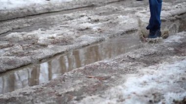 Parkta su birikintileri üzerinde çalışan adam. Su dağılım partilere sıçraması. Eğlence, spor. Erken Bahar.