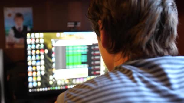 Egy fiatal szoftver mérnök srác dolgozik az irodájában a számítógépen. Írja kódot, a program — Stock videók
