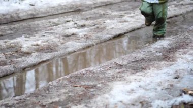 Parkta su birikintileri üzerinde çalışan bir çocuk. Su dağılım partilere sıçraması. Eğlence, spor