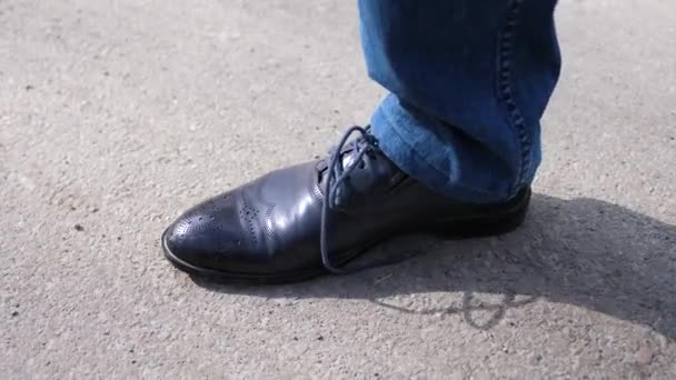 Tipo ata sus cordones de cerca El tipo se detiene y ata los cordones en los zapatos. Zapatos de cerca — Vídeos de Stock