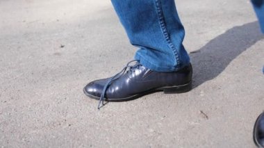 adam yakın düzenleyebilirim adam durur ve dantel üzerinde ayakkabı bağları ayakkabı bağı bağlar. Ayakkabı yakın çekim