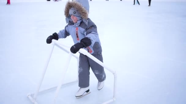 Das Kind wird zum Schlittschuhlaufen ausgebildet. Frühes Training im Eiskunstlauf. Sport im Freien — Stockvideo