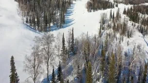 滑雪坡度。 滑雪者和滑雪者沿着跑道滑行. 滑雪者滑向宽阔的滑雪场时的空中摄影 — 图库视频影像
