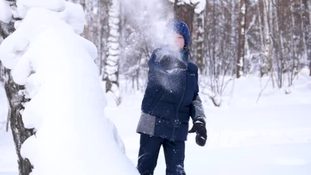 A child plays in the open air in winter, throws snow. Active outdoor sports. — 비디오