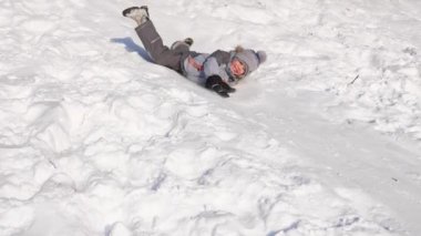 Bir çocuk karlı bir dağda ata biner ve oynar. Ağır çekim. Karlı kış manzarası. Açık hava sporları