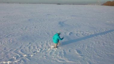 The girl goes through deep snowdrifts overcoming difficulties. Walking and outdoor sports.