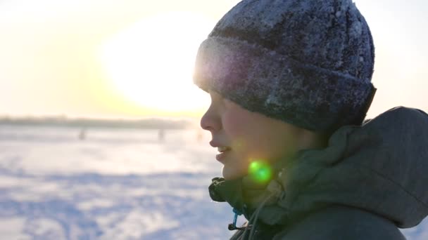 Een tiener in winter Park, gezicht close-up. Het tijdstip van zonsondergang. Wandelingen in de frisse lucht. Gezonde levensstijl — Stockvideo