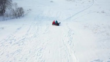 Family rides on a snowy mountain. Shooting from a height. Snowy winter landscape. Outdoor sports