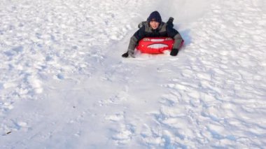 Bir çocuk karlı bir dağda ata biner ve oynar. Ağır çekim. Karlı kış manzarası. Açık hava sporları