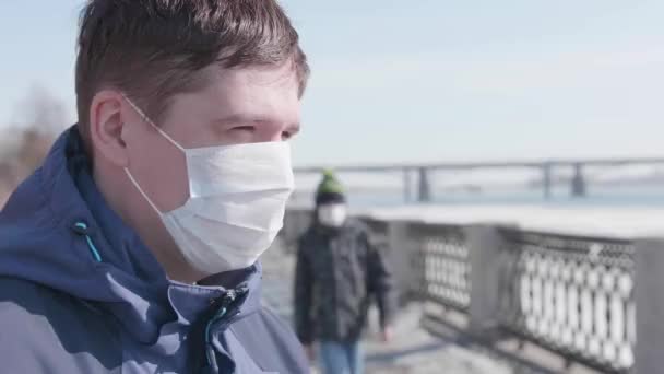 Een man met een beschermend masker op straat. Preventie en bescherming van de gezondheid en de veiligheid van het leven. Coronavirus N1H1, covid-19, een pandemie in de wereld. — Stockvideo