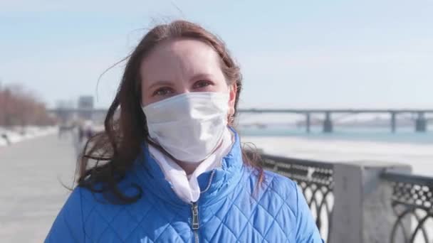 Kız sokakta koruyucu maskesini çıkarıyor. Sağlık ve can güvenliğinin önlenmesi ve korunması. Coronavirus N1H1, covid-19, dünyada salgın hastalık. — Stok video