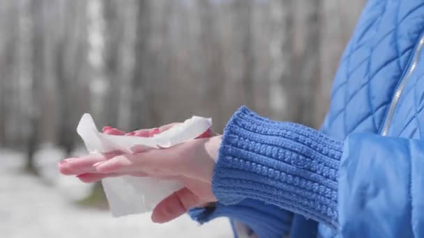 Flickan torkar händerna med en antibakteriell servett på gatan. Förebyggande och skydd av människors hälsa och säkerhet. — Stockvideo