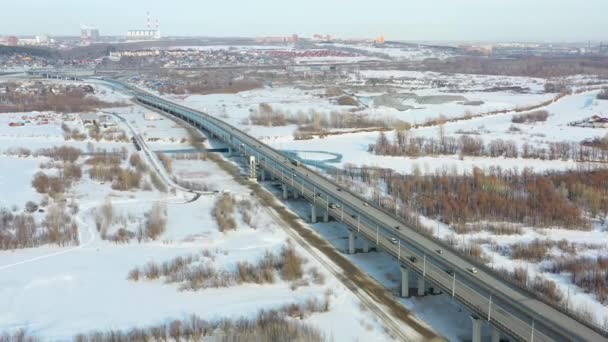 Estrada suburbana, fotografia aérea de drones. Uma pequena aldeia coberta de neve perto da estrada . — Vídeo de Stock