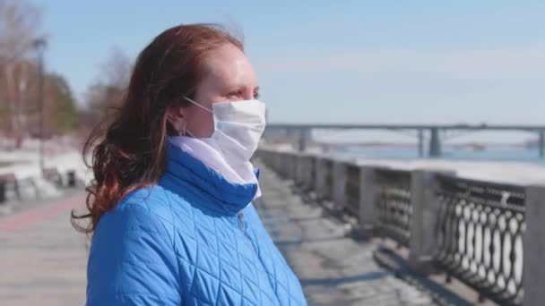 Een meisje met een beschermend masker op straat. Preventie en bescherming van de gezondheid en de veiligheid van het leven. — Stockvideo