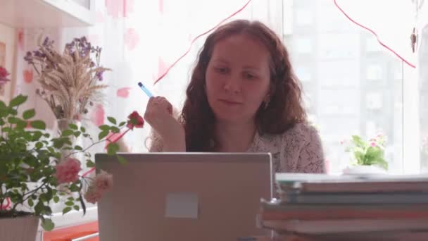 Lo studente guarda la lezione online e impara a casa. Una giovane ragazza fa i compiti mentre guarda lo schermo del computer. Istruzione scolastica . — Video Stock