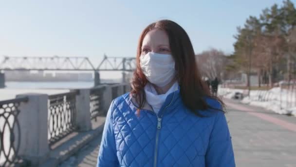Ένα κορίτσι περπατάει στο δρόμο με μια προστατευτική μάσκα. Πρόληψη και προστασία της υγείας και της ασφάλειας ζωής. — Αρχείο Βίντεο