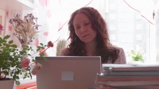 Lo studente guarda la lezione online e impara a casa. Una giovane ragazza fa i compiti mentre guarda lo schermo del computer. Istruzione scolastica . — Video Stock