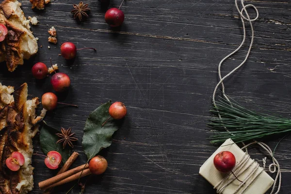 Crostata di mele natalizie su tavolo di legno nero con regalo e costoletta — Foto Stock