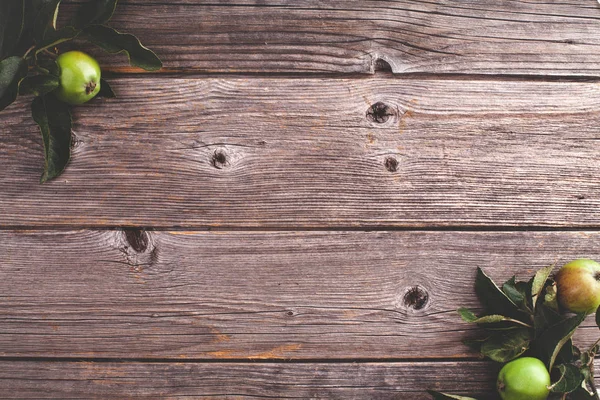 Ahşap arka plan köşesinde yaprakları ile elma