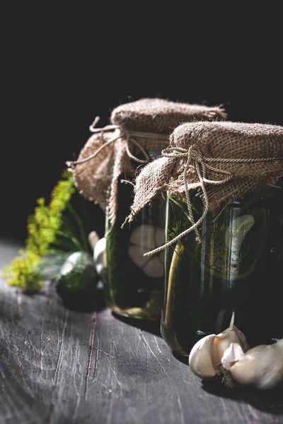 Sarımsak ve siyah tabl üzerine dereotu salatalık turşusu iki kavanoz