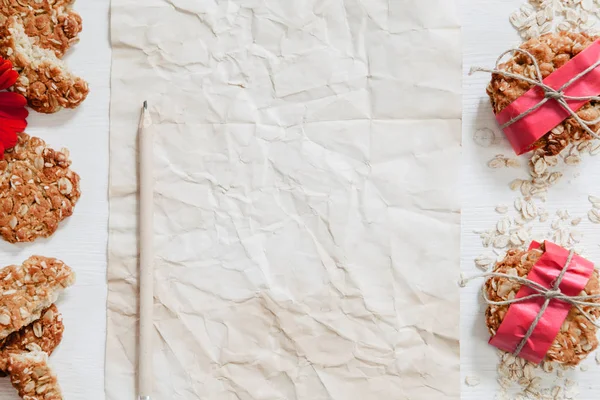 Здорове веганське вівсяне печиво з червоними квітами, папером та олівцем — стокове фото